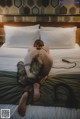 A naked woman laying on a bed with a fur collar.